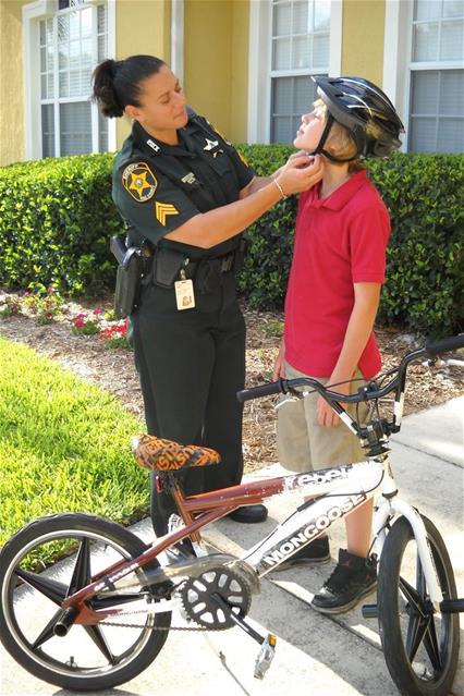 Stephanie Taitlian buckles a child's helmet